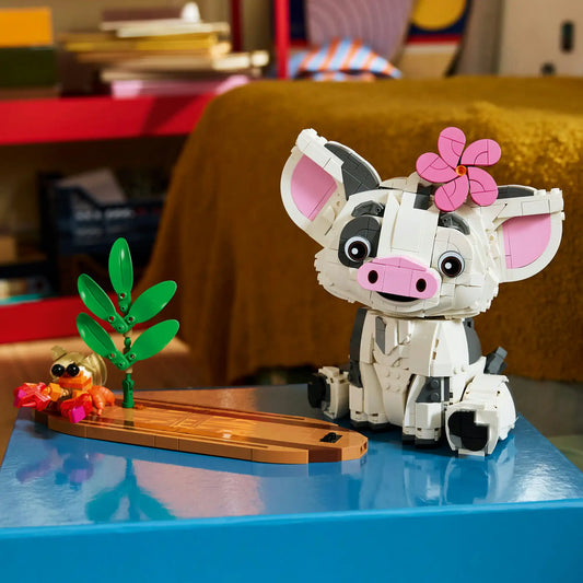 LEGO Disney: Pua 43292, 885 darabos készlet megépített Pua figurája trópusi talapzaton, pálmalevelekkel, virággal és egy kis rák figurával, dekoratív kiállítási környezetben.