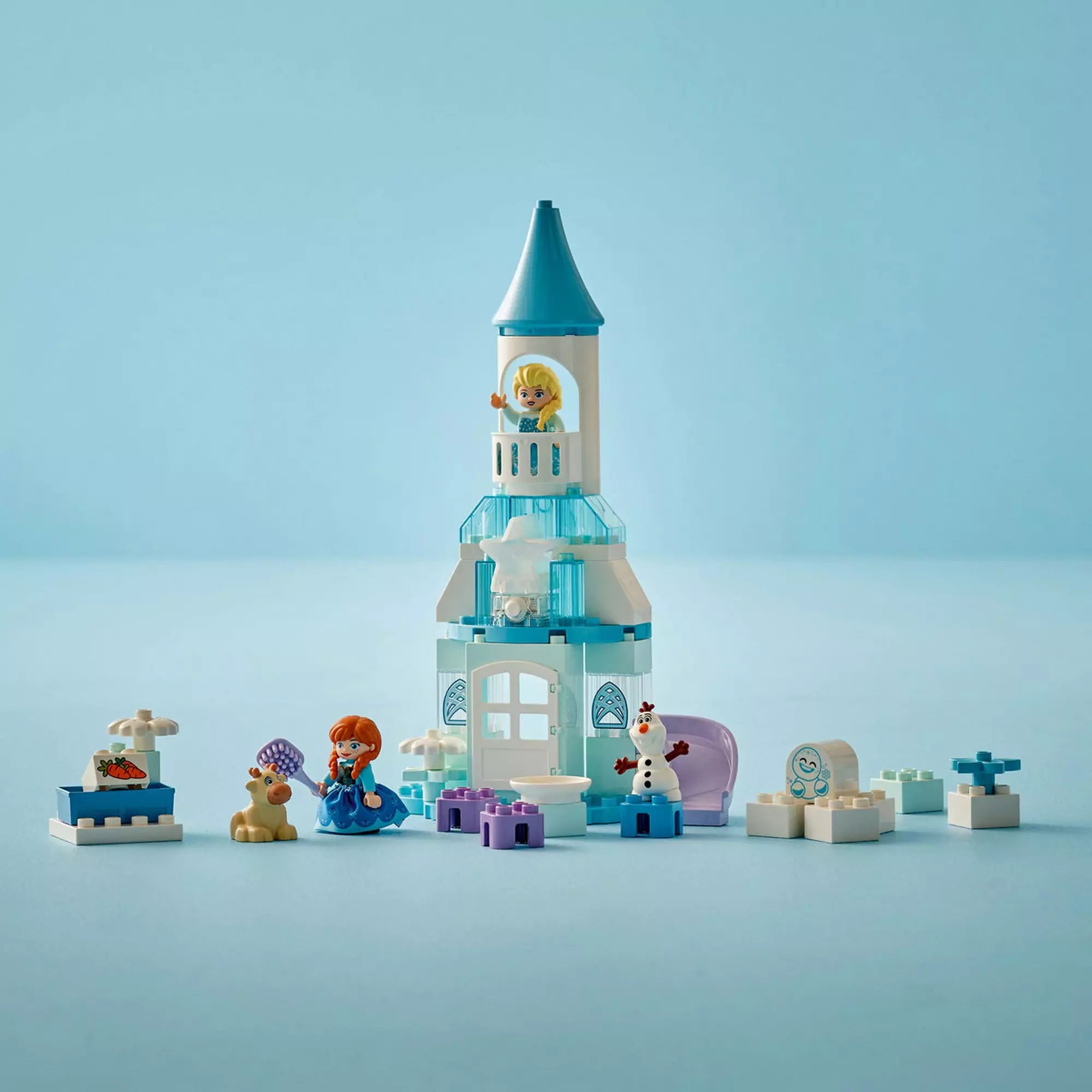 LEGO Duplo: Anna és Elza jégkastély partija (10455) felépített játékkastély figurákkal és elemekkel világoskék háttér előtt.