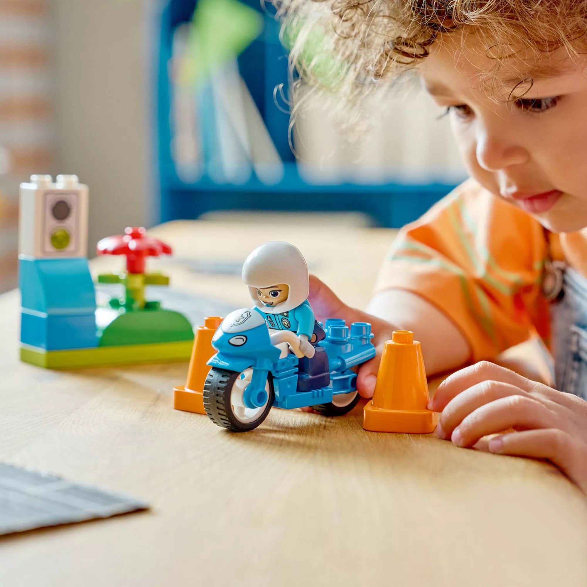 Kék rendőrségi motorkerékpár (10471) – Közeli életkép a DUPLO rendőrmotoros játékról és a közlekedési kiegészítőkről.