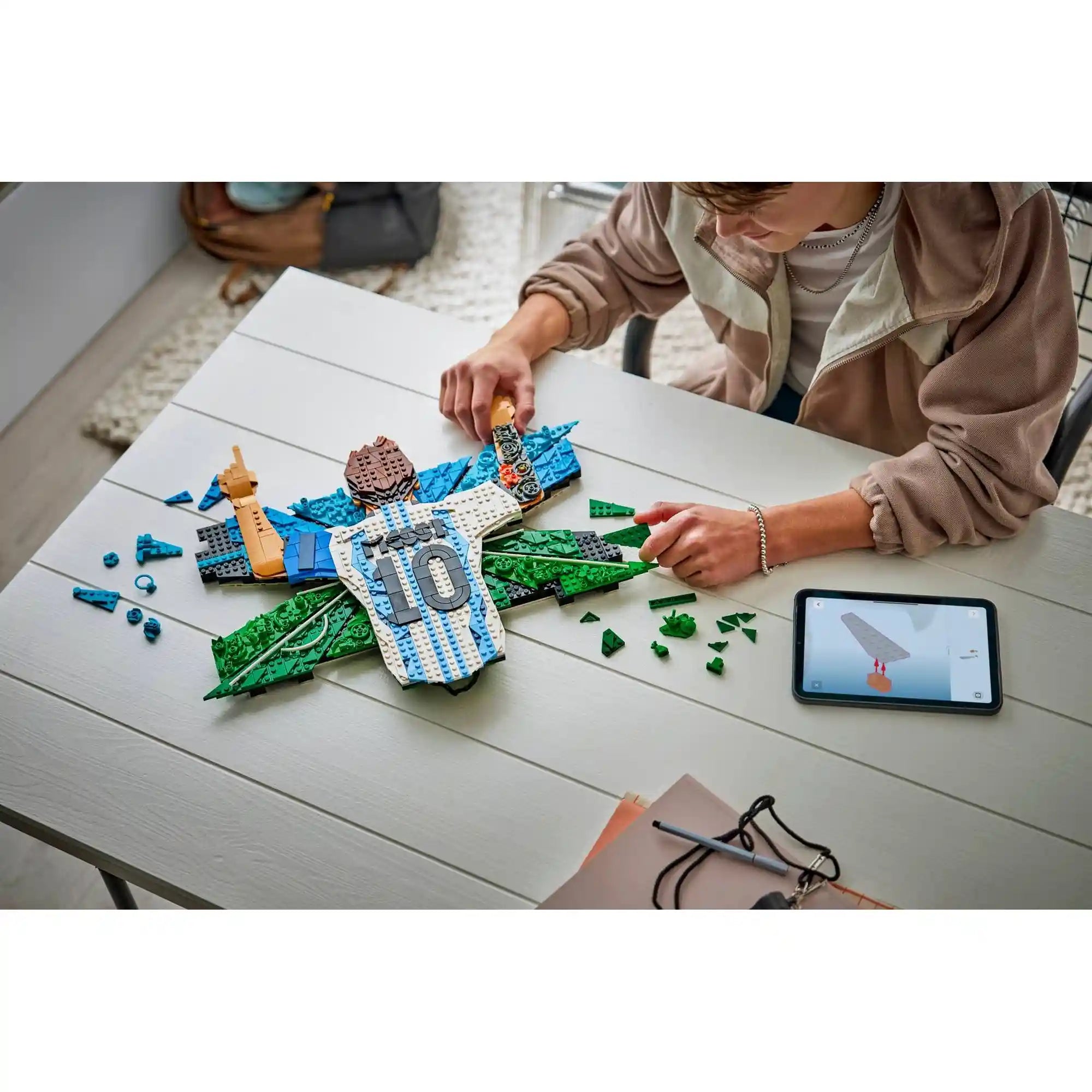Fiatal építő a LEGO Editions Lionel Messi – Gólöröm (43018) készleten dolgozik, miközben a LEGO Builder alkalmazás digitális útmutatóját használja a modell összeállításához.