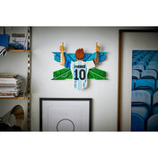 LEGO Editions Lionel Messi – Gólöröm (43018) kész faldekoráció egy szoba falán elhelyezve, Messi ünneplő mozdulatával, az ikonikus 10-es mez számmal és részletgazdag háttérrel.