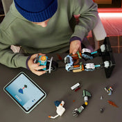 Gyermek építi a LEGO Fortnite KIT robotfigurát, miközben a LEGO Builder alkalmazás digitális útmutatóját használja egy táblagépen.