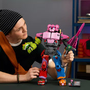 Egy fiatal felnőtt kézben tartja a LEGO Fortnite Mecha Team Leader (77078) robotot, kiemelve a méretét és részletgazdag kialakítását.