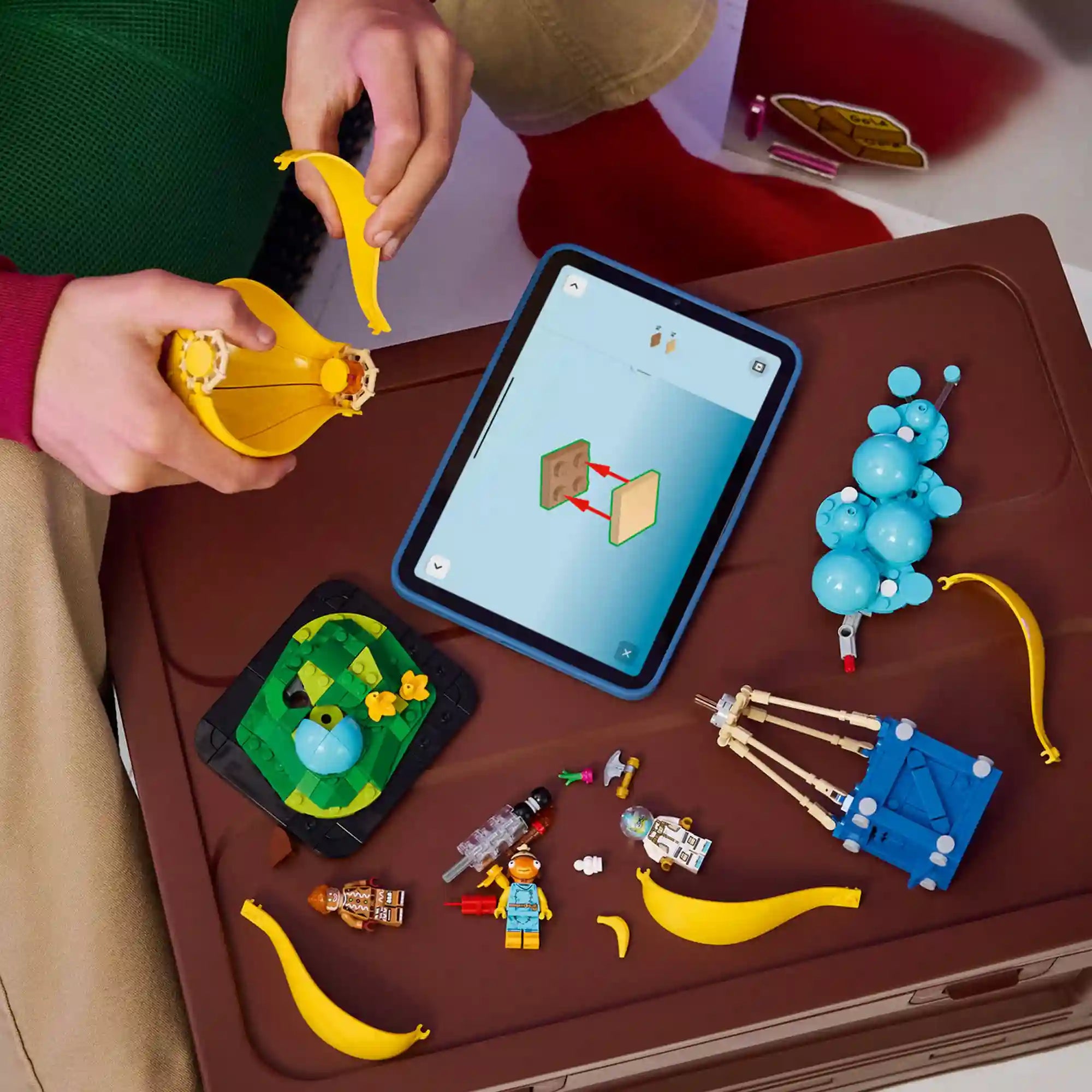 Gyermek építi a LEGO Fortnite Supply Drop készletet a LEGO Builder alkalmazás digitális útmutatójának segítségével táblagépen.