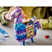 Közelkép a LEGO Fortnite Supply Llama nyitható testéről, amelybe különféle kiegészítő elemek – például italok, felszerelések és egy mini láda – helyezhetők. A részletgazdag építés jól látható.