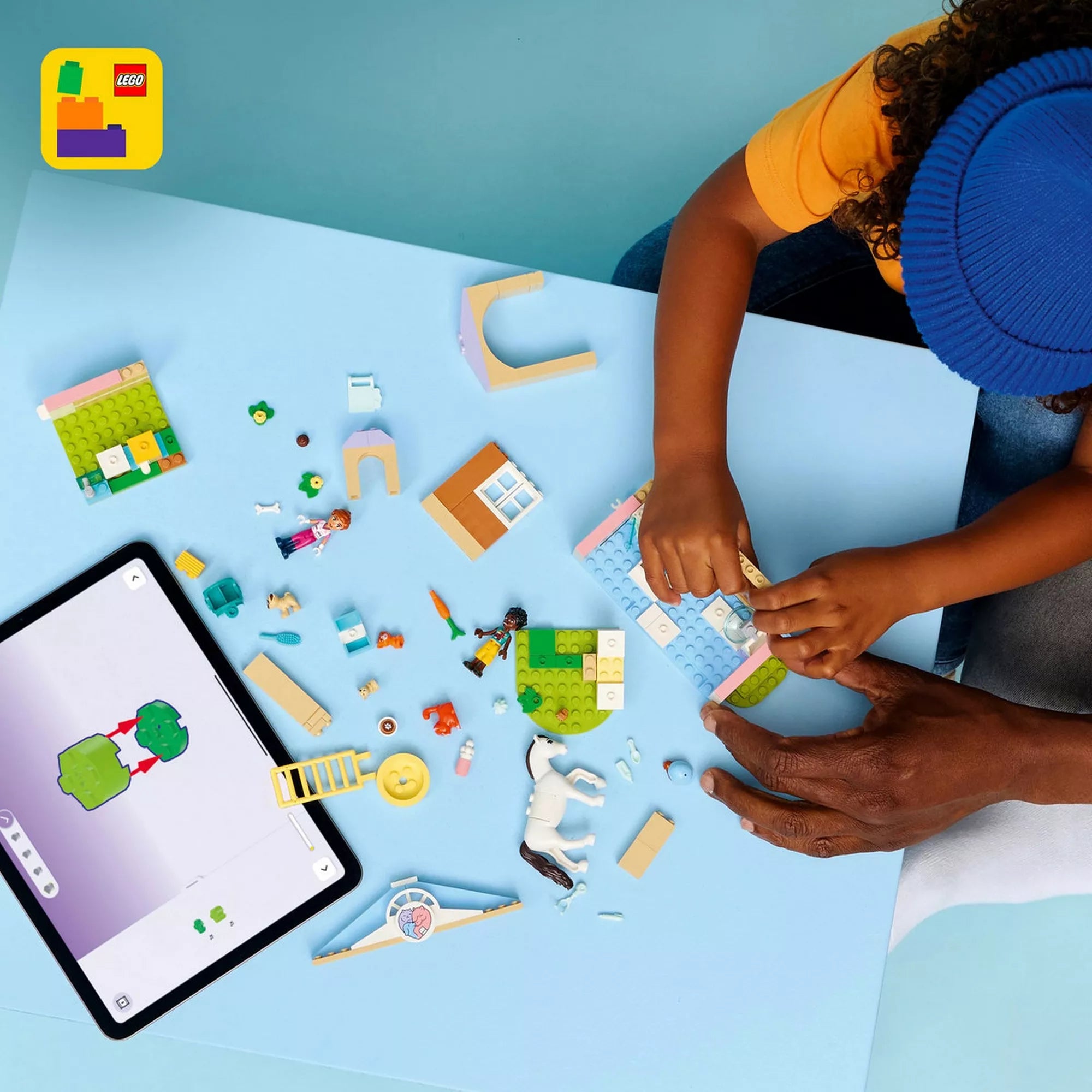 LEGO Friends Állatorvosi klinika építése LEGO Builder alkalmazással, gyermek kezei és a készlet elemei építés közben