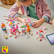LEGO Friends: Cukorkával és muffinnal díszített óriáskerék 42700, 602 darabos készlet játék közben, ahol egy gyermek az óriáskereket és az édességes attrakciókat építi és használja.