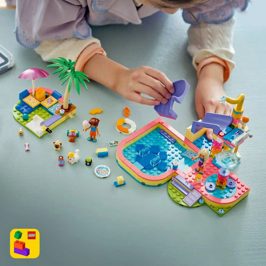Gyermek a LEGO Friends 42676 aquapark készlettel játszik, miközben a házi kedvencek a csúszdán és a medencében szórakoznak.