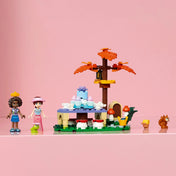 LEGO Friends Erdei teázás 42690 szett Aliya és Paisley figurákkal, állatbarátokkal, teázóasztallal és dekoratív fával.