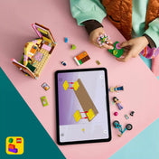 Gyermek a LEGO Builder alkalmazás 3D építési útmutatóját követi a LEGO Friends Glamping kabin 42682 készlet építése közben.