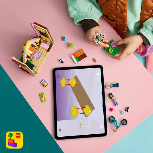Gyermek a LEGO Builder alkalmazás 3D építési útmutatóját követi a LEGO Friends Glamping kabin 42682 készlet építése közben.