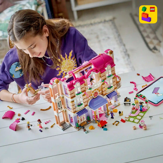 Gyermek építi a LEGO Friends Heartlake City Grand Hotel szállodát, miközben a LEGO Builder alkalmazás digitális útmutatóját használja.