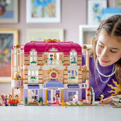 Gyermek játszik a LEGO Friends Heartlake City Grand Hotel készlettel, miközben felfedezi a szálloda szobáit, erkélyeit és működő liftjeit.