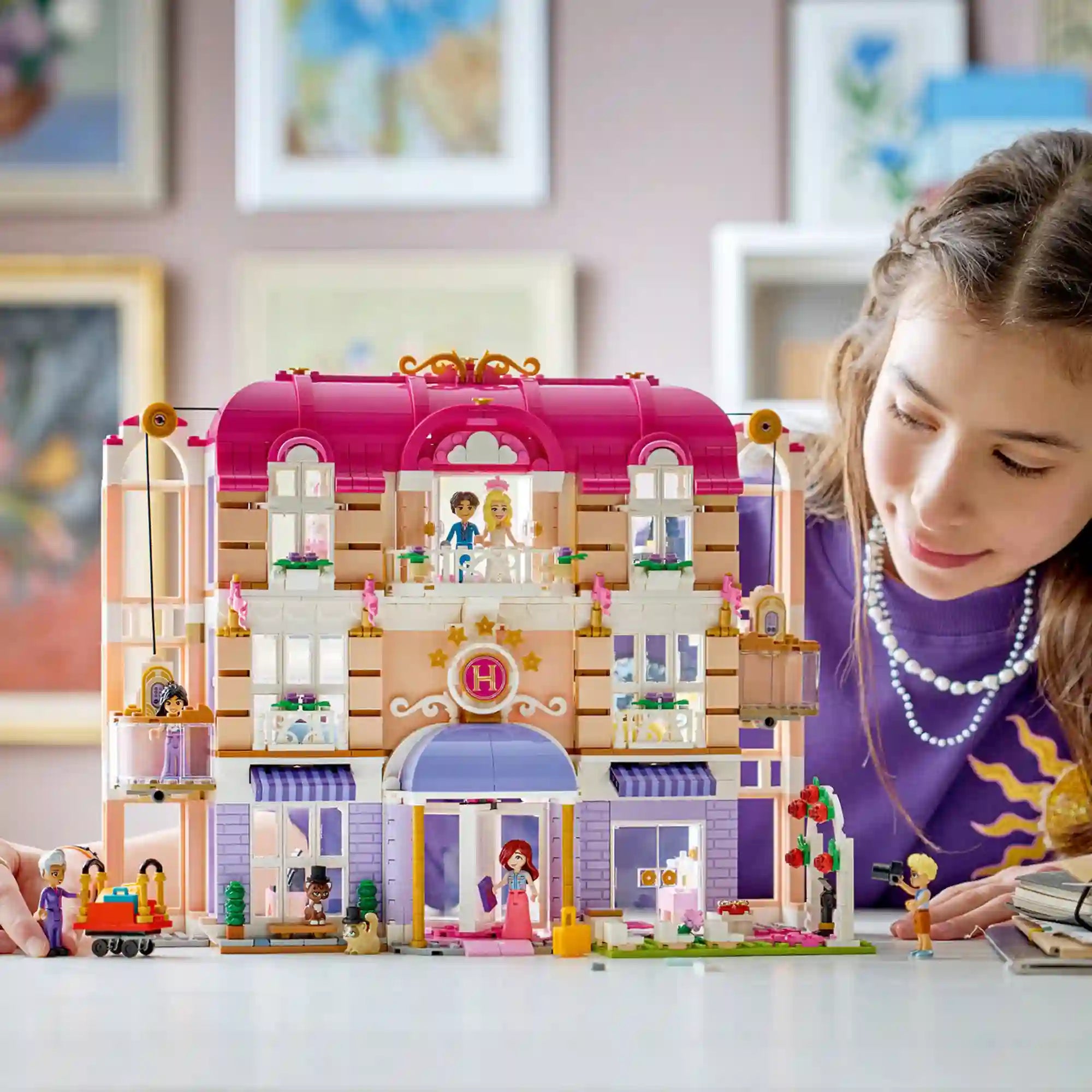 Gyermek játszik a LEGO Friends Heartlake City Grand Hotel készlettel, miközben felfedezi a szálloda szobáit, erkélyeit és működő liftjeit.