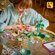 LEGO Friends: Körhinta virágokkal és tündérekkel 42702, 321 darabos készlet játék közben, ahol egy gyermek a virág alakú forgó attrakció elemeit építi és használja.