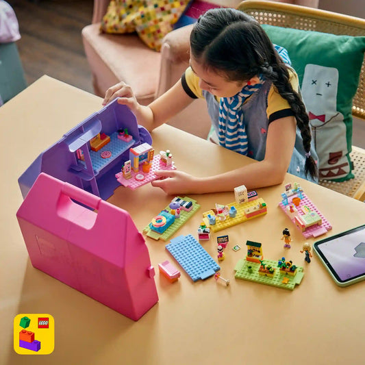 Gyermek játszik a LEGO Friends Kreatív, bőröndalakú babaház készlettel, miközben különböző szobákat rendez be és történeteket alkot.