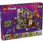 A LEGO Friends Otthonos kabin az őszi erdőben hátoldali dobozképe, amely bemutatja a házikó belső tereit, a kandallót, a hálószobát és az interaktív funkciókat.