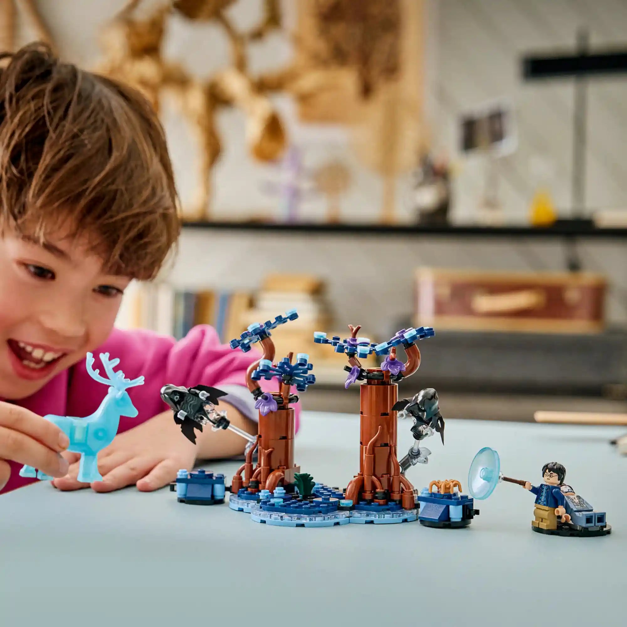 Gyermek játszik a LEGO Harry Potter Tiltott Rengeteg jelenettel, miközben Harry Potter a szarvas patrónus segítségével szembeszáll a dementorokkal.