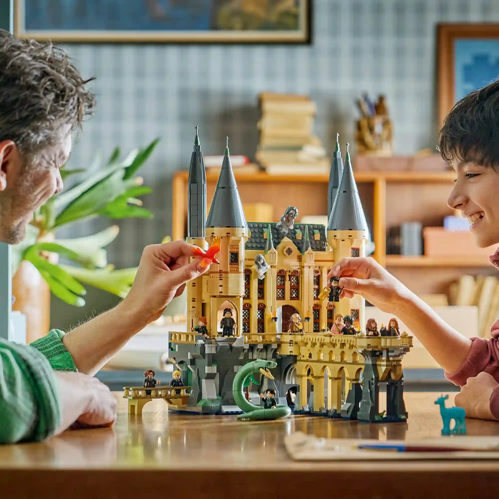 LEGO Harry Potter Roxfort kastély Keleti szárny 76473 életkép, ahol apa és gyermek játszik a részletes kastélymodellel.