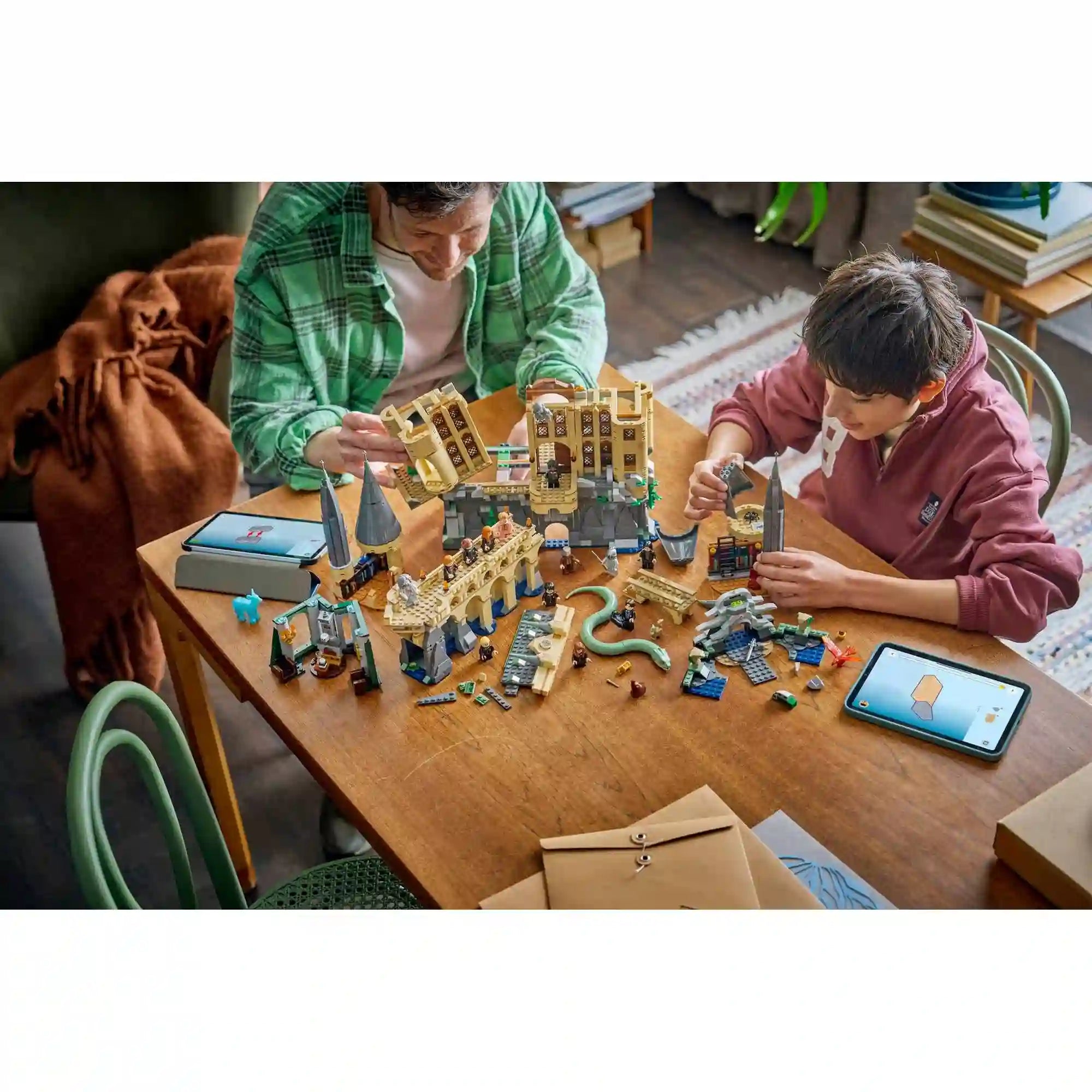 LEGO Harry Potter 76473 építési jelenet, ahol apa és gyermek a Roxfort kastély moduljait rakja össze LEGO Builder app segítségével.