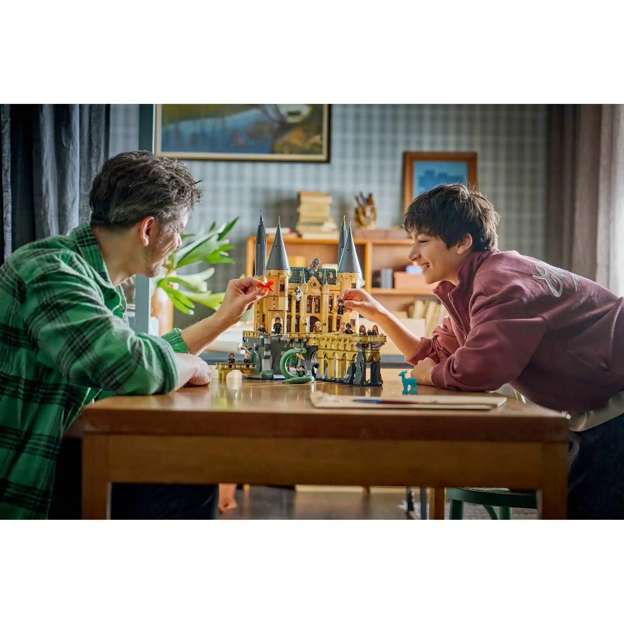 LEGO Harry Potter 76473 életkép apa és gyermek közös játékával, Roxfort kastéllyal, minifigurákkal és Fawkes figurával.
