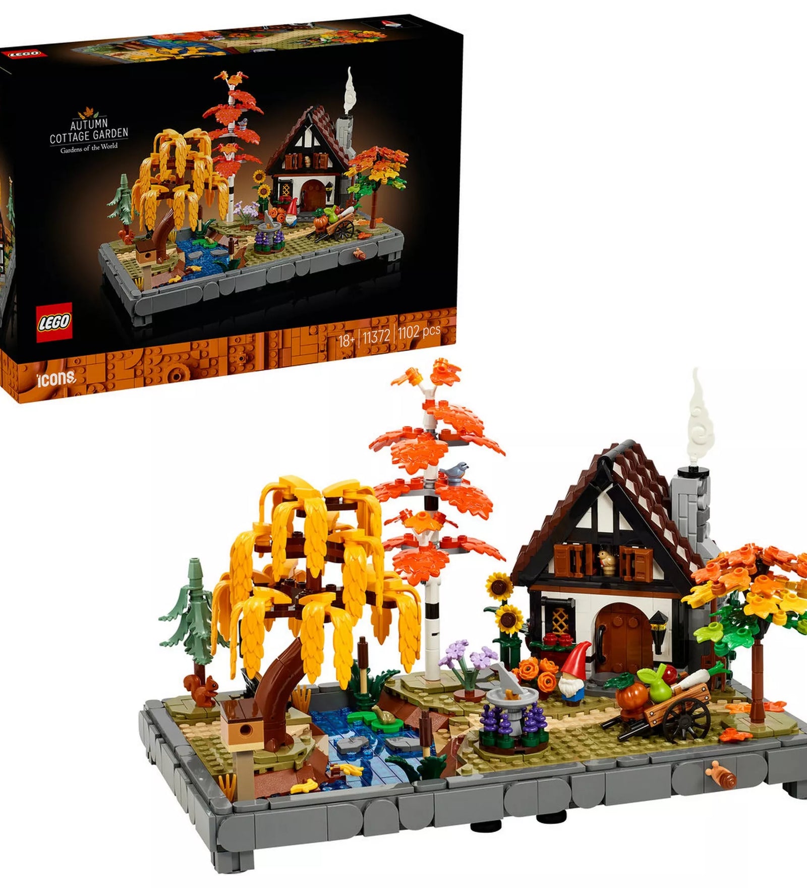 A LEGO® Icons Őszi kert házikó (11372) kész modellje a doboz mellett, bemutatva az elkészült őszi diorámát és a készlet végső megjelenését