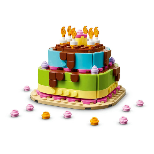 A LEGO 40815 Születésnapi torta összeépített modellje kék és zöld emeletekkel, csokoládécsorgással, gyertyákkal és színes díszítőelemekkel.