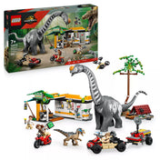 „A LEGO Jurassic World 76973 doboza és a teljesen megépített készlet: Titanosaurus, Velociraptor, járművek, táborállomás, drón és a három minifigura együtt fehér háttér előtt.”