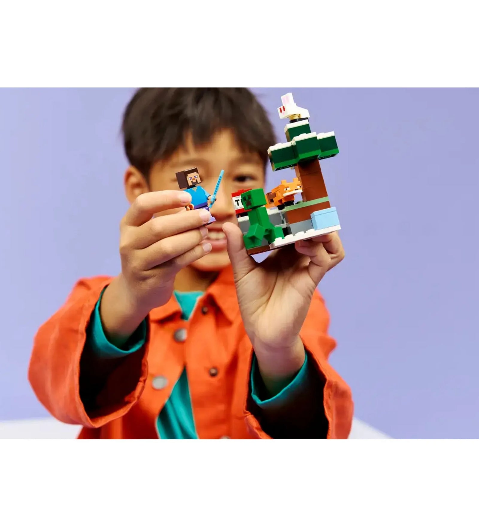 LEGO Minecraft Steve’s Taiga Adventure 21583 készlet játék közben, gyermek kezében tartott Steve figura és tajga építmény.