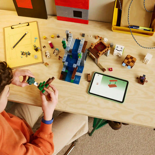 Gyermek építi a LEGO Minecraft Szellemkikötő (21597) készletet, miközben a LEGO Builder alkalmazás digitális útmutatója segíti az összeszerelést.
