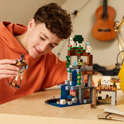 Minecraft rajongó gyermek a repülő szellemléghajót mozgatja a LEGO Szellemkikötő jelenet felett. A vízeséses barlang és a különféle mobok izgalmas kalandokat idéznek meg.