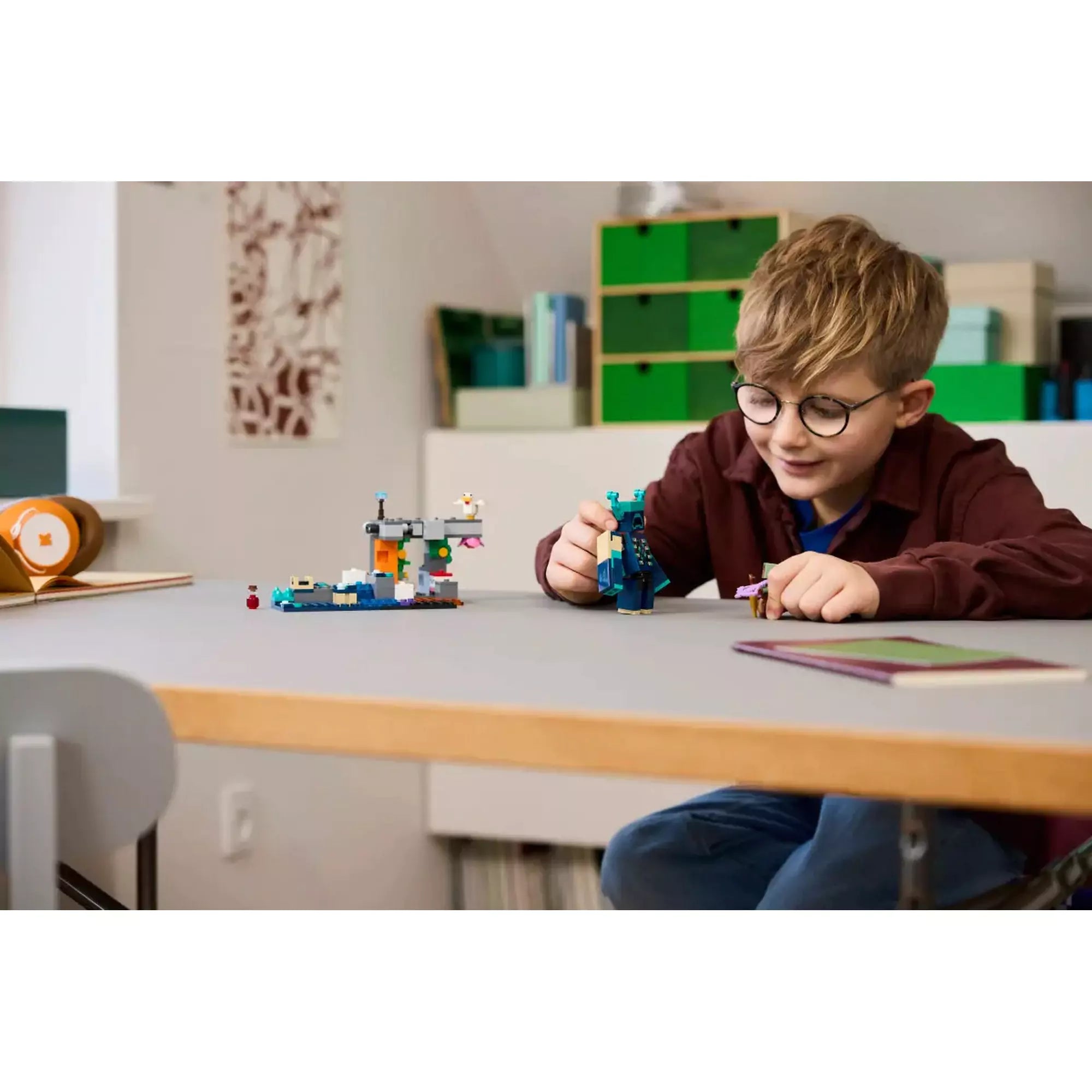 Fiú játssza el a LEGO Minecraft Találkozás az Őrzővel történetét, miközben a kalandor és az Őrző figurát mozgatja a készlethez tartozó jelenetben.
