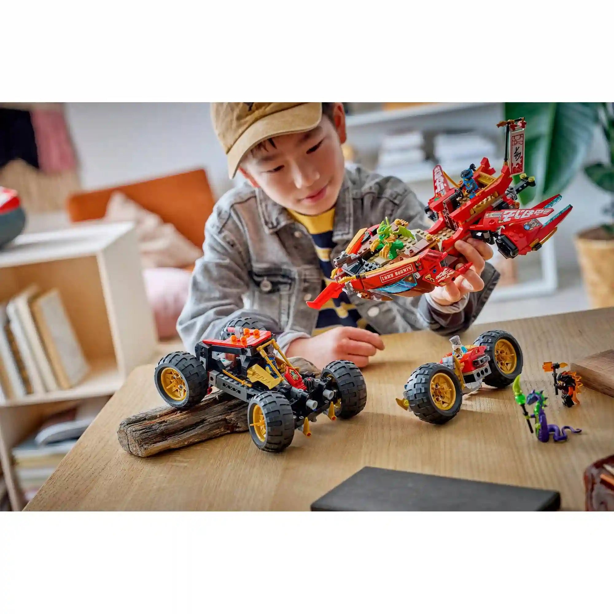 Gyermek játszik a LEGO NINJAGO A föld adománya 71869 készlettel, miközben a jármű különálló modelljeit használja.