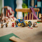 A LEGO NINJAGO Jay átalakuló járműve összeépítve, az asztalon elrendezett minifigurákkal és kiegészítő elemekkel, valós játékkörnyezetben, filmes hangulatú háttérrel.