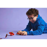  Gyerek játék közben, kipróbálva a LEGO Ninjago Kai sárkány Spinjitzu pörgettyűjének (71823) pörgési képességeit.