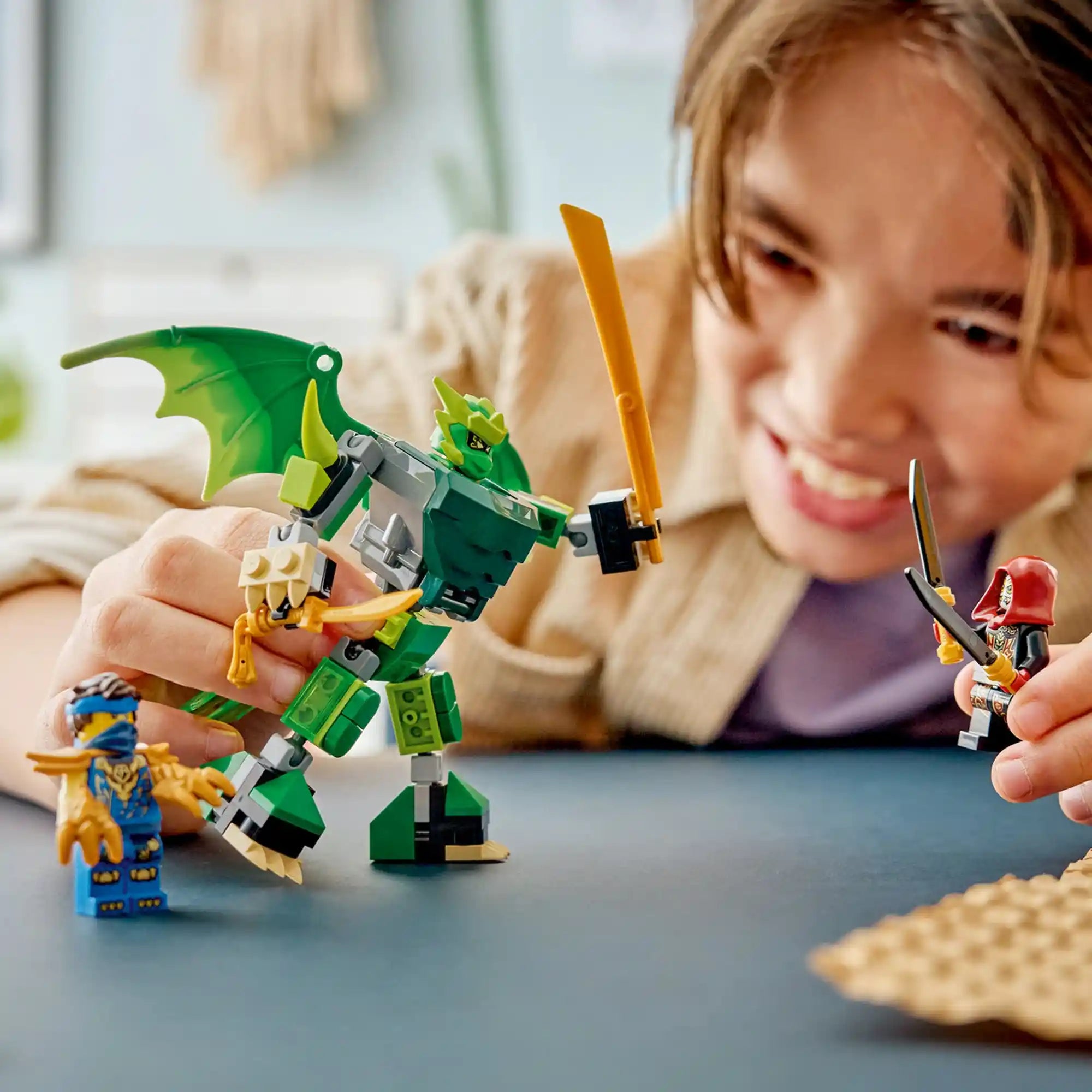 Gyermek játszik a LEGO NINJAGO Lloyd sárkánypáncélja, harci csomag 71862 készlettel, miközben a sárkányrobot összecsap a Lojalistával.