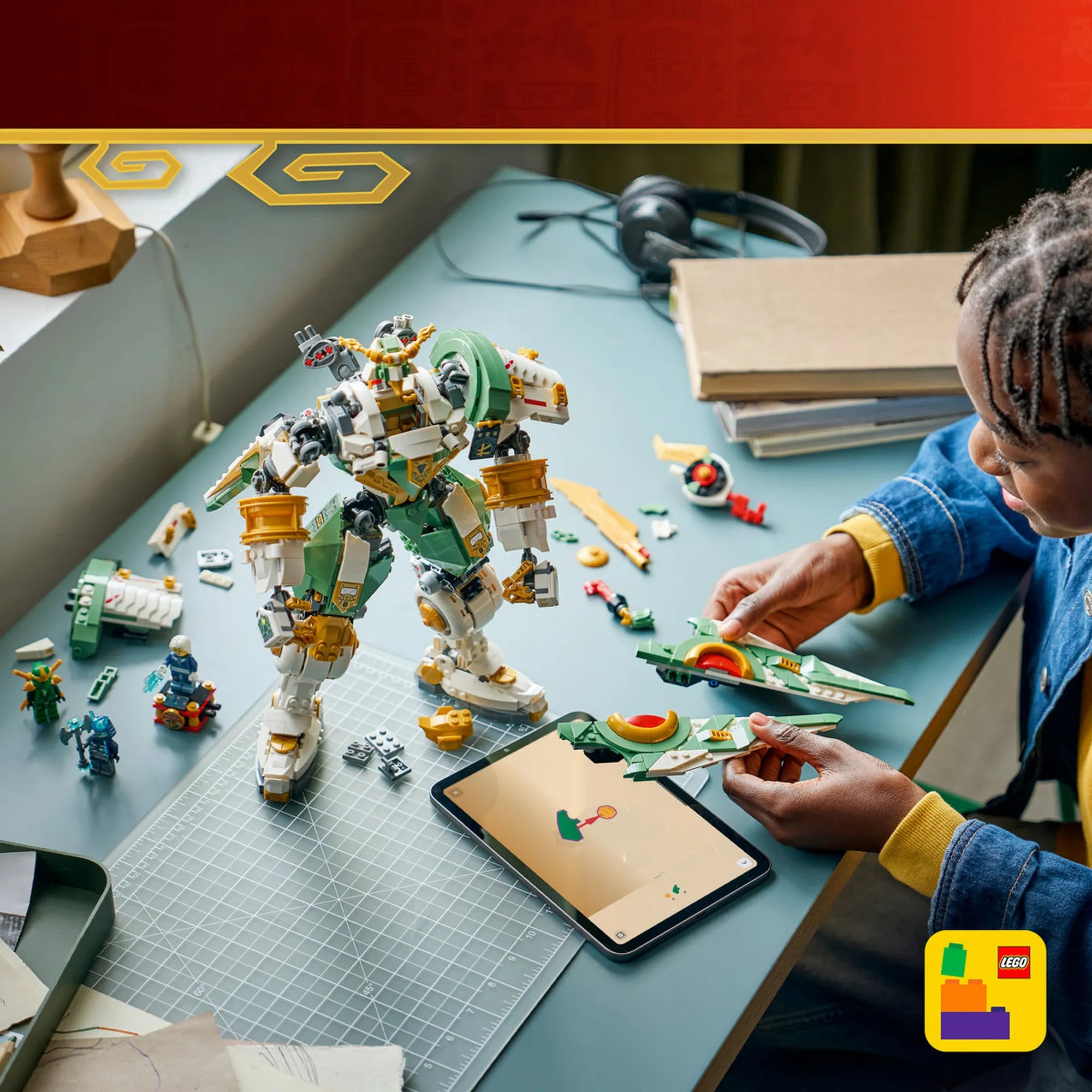 LEGO Ninjago: Lloyd titánpáncélja a 15. évfordulóra 71860, 1293 darabos – játék közben épített titán mech modell, gyerek a szárny elemeket szereli az asztalon.