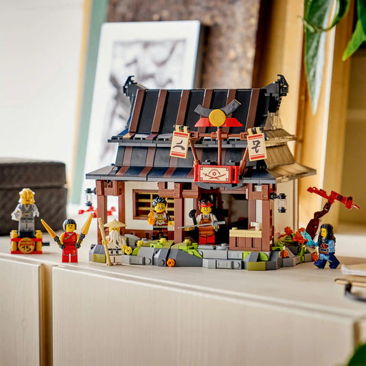 LEGO NINJAGO: Négy Fegyver Kovácsműhely, 15. évforduló készlet megépített kovácsház épülettel és minifigurákkal kiállítva polcon.