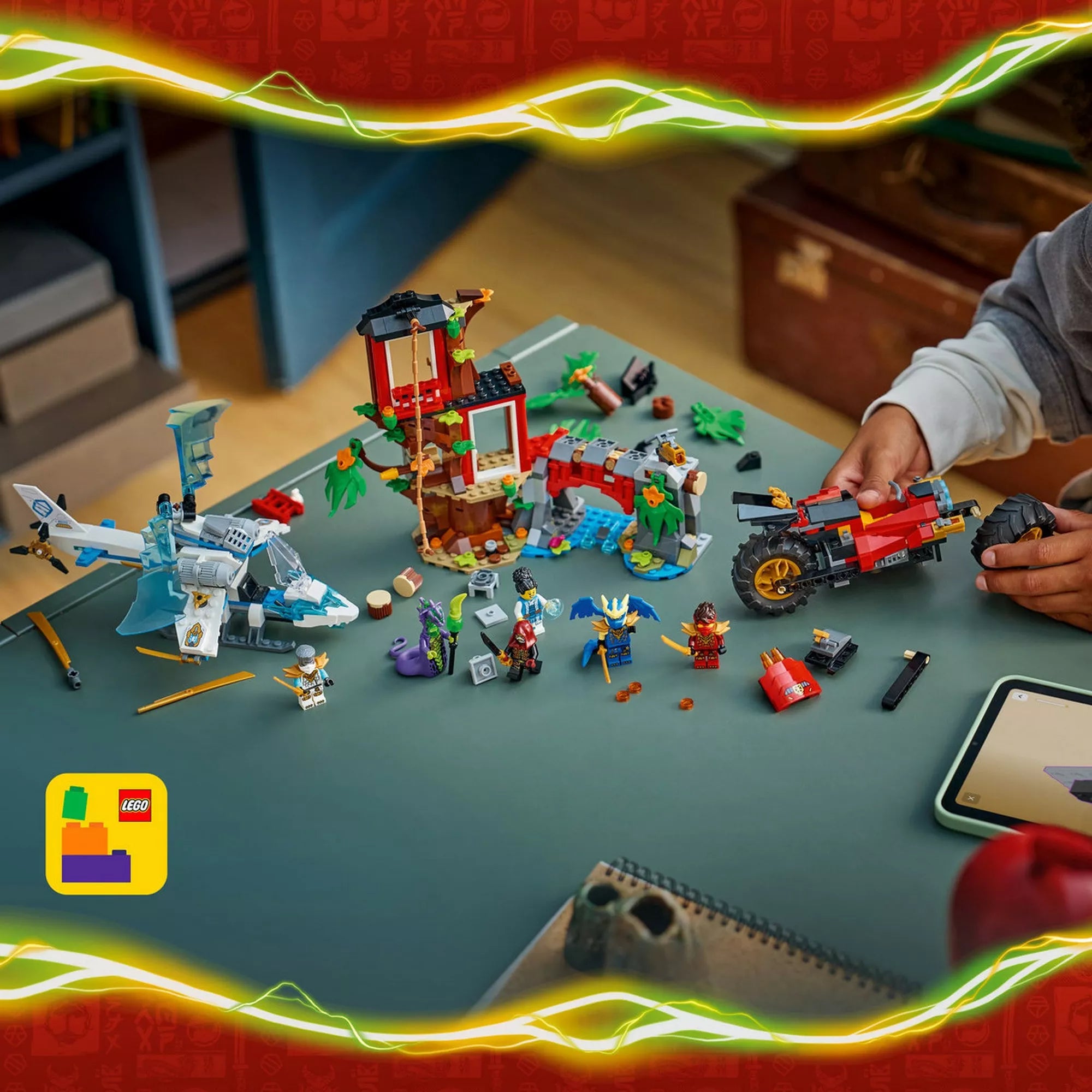 Felülnézeti kép a LEGO NINJAGO 71857 készlet elemeiről játék közben, a lombházzal, a helikopterrel, a ninja motorral és a minifigurákkal elrendezve.