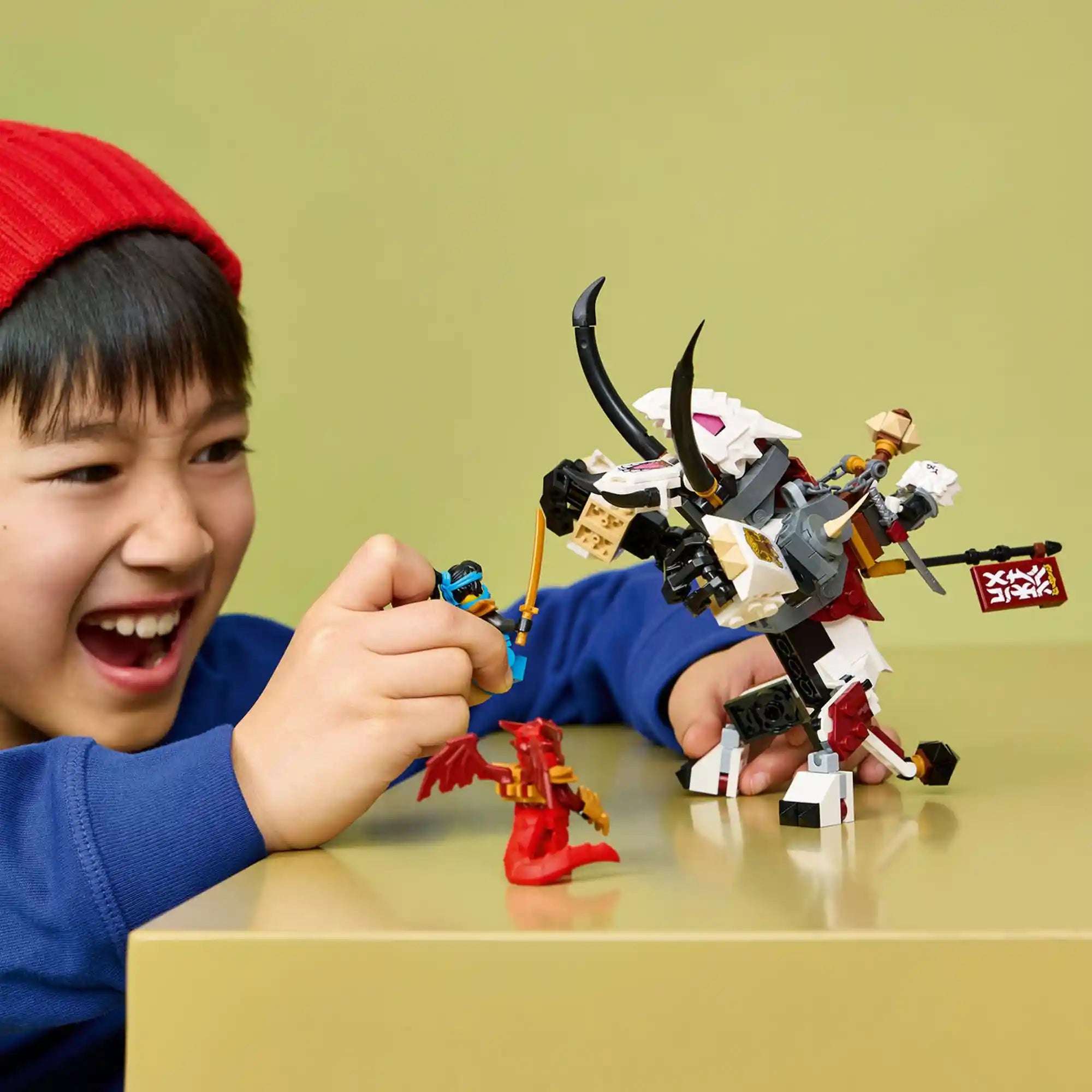 Gyermek a LEGO NINJAGO Grimtak sárkányszörny modellel játszik, miközben Nya és Kai minifigurákkal izgalmas csatajelenetet alakít ki.