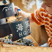 A LEGO ONE PIECE: Garp tengeri csatahajója 75646 játék közben, ahol egy gyermek a részletgazdag hadihajón helyezi el a minifigurákat.