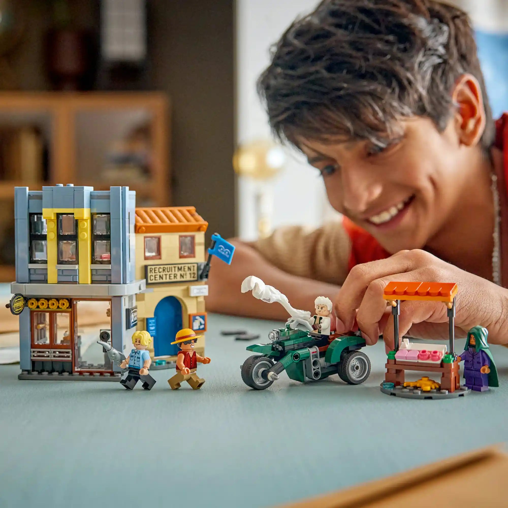 Gyermek játszik a LEGO ONE PIECE Leszámolás Smoker kapitánnyal 75642 készlettel, Loguetown épületeivel, motorkerékpárral és minifigurákkal.