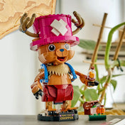 A megépített LEGO ONE PIECE Tony Tony Chopper figura gyógyszeres üveggel és kiegészítőkkel kiállítva.