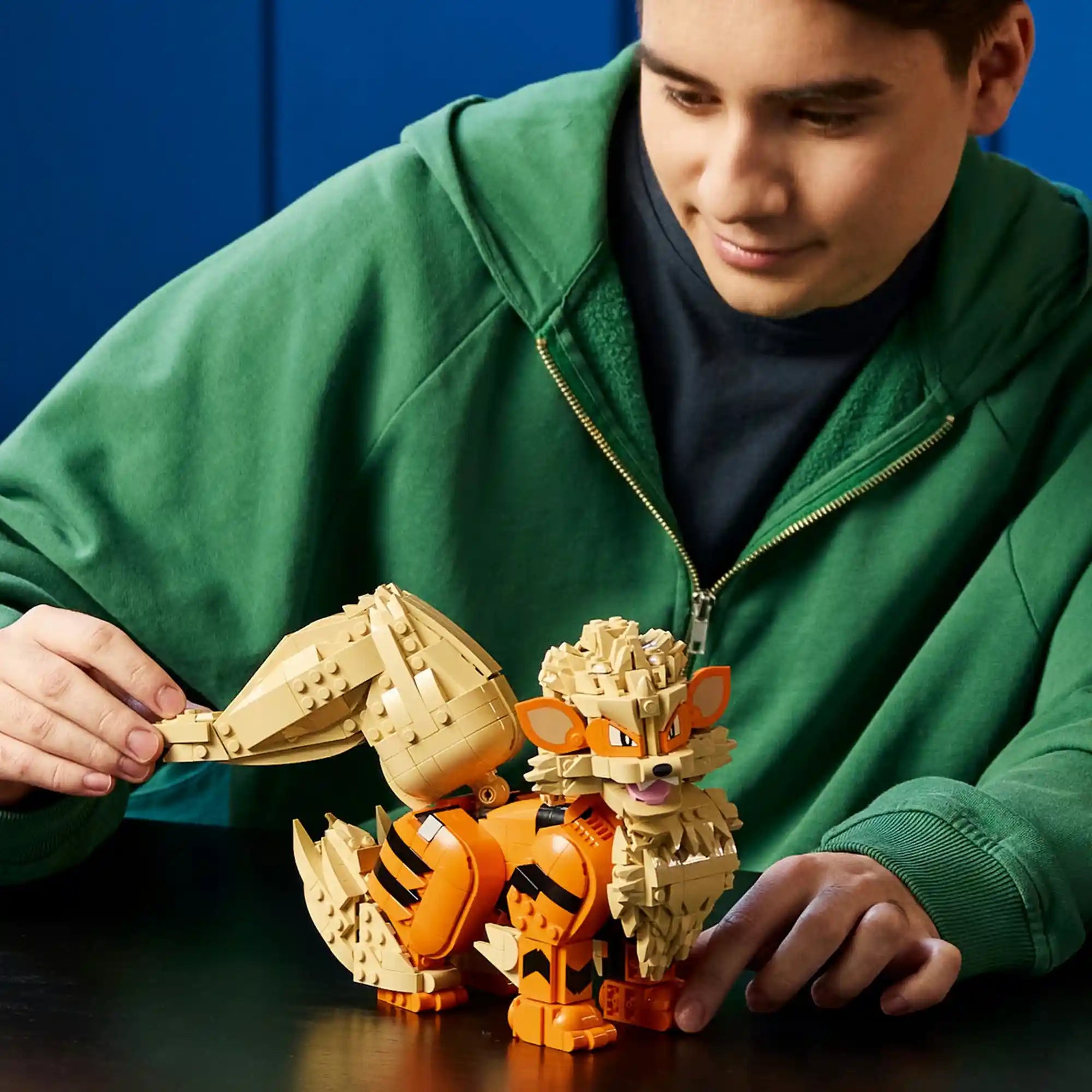 A LEGO Pokémon: Arcanine 72160 készlettel játszó építő, aki az Arcanine figura mozgatható farkát állítja be.