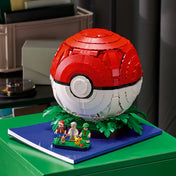 LEGO Pokémon: Ikonikus Trénerpillanatok Pokélabda 72154 zárt, piros-fehér gömb alakú modellje zöld leveles talapzaton.