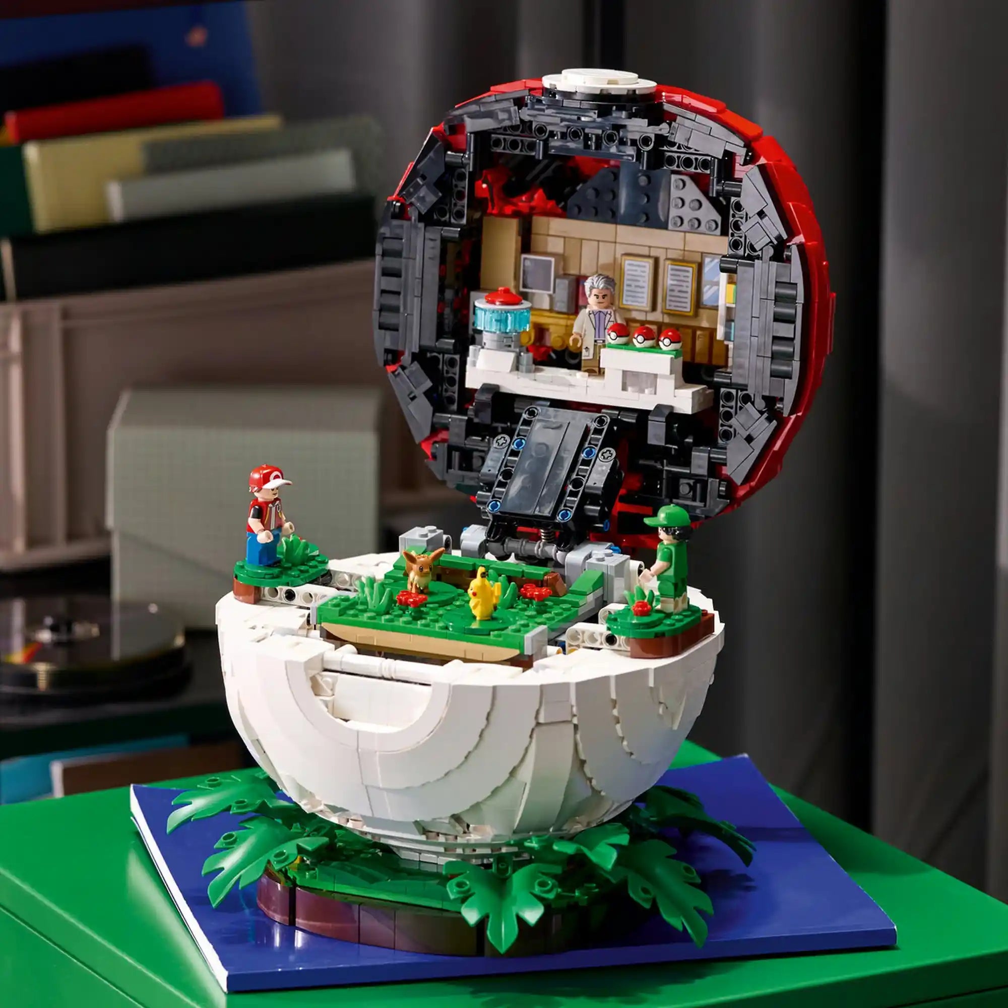 LEGO Pokémon: Ikonikus Trénerpillanatok Pokélabda 72154 kinyitott belseje, Pokémon-laborral, három Pokélabdával, Pikachuval és Eevee-vel.