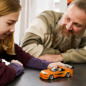 Gyermek és felnőtt együtt játszik a LEGO Speed Champions Halálos iramban Toyota Supra MK4 modellautóval.