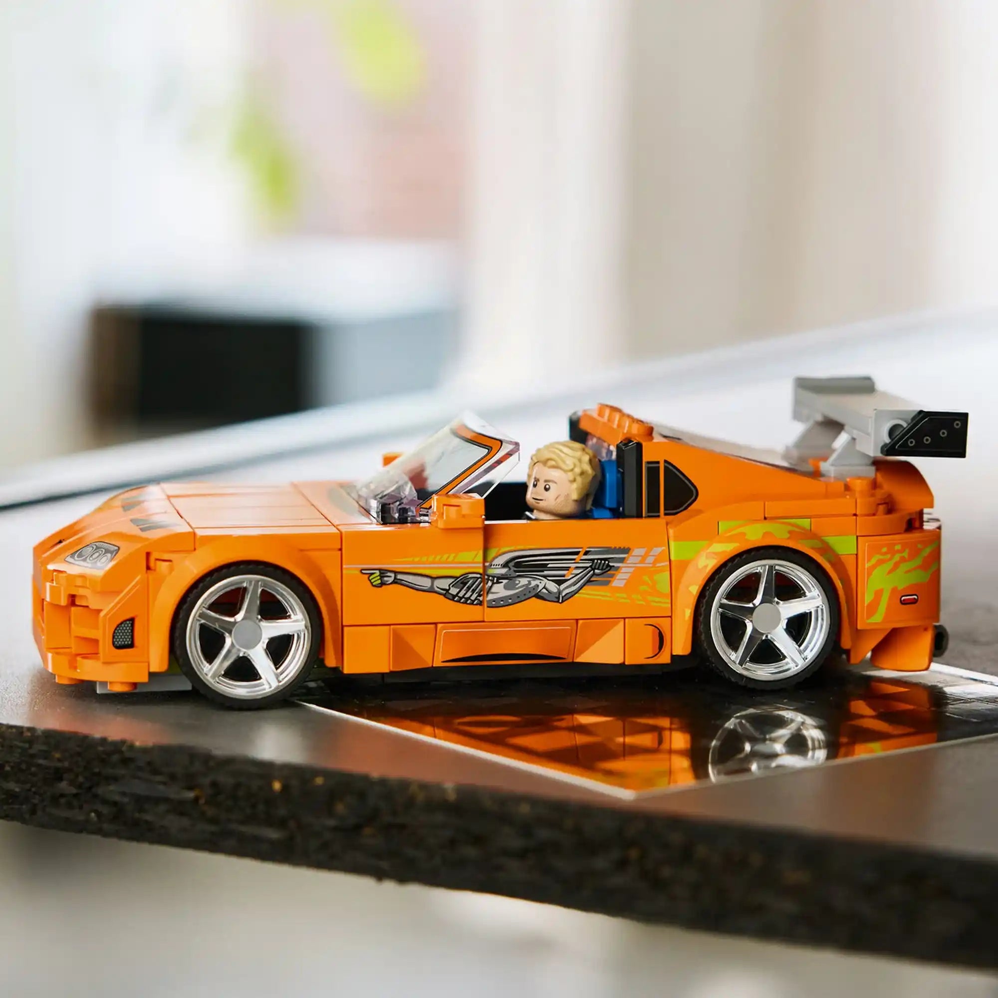 LEGO Toyota Supra MK4 narancssárga modellautó polcon kiállítva, részletgazdag karosszériával és hátsó szárnnyal.