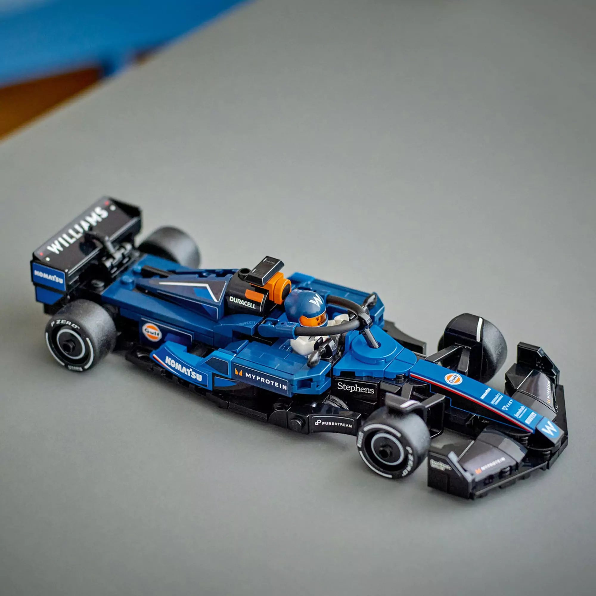 A LEGO FW46 autó mozgás közben, a pilóta minifigura a volán mögött ül, versenykész állapotban.