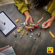 LEGO Star Wars Cobb Vanth speeder építése folyamatban, szétszedett elemekkel, minifigurákkal és a LEGO Builder alkalmazás 3D útmutatójával egy táblagépen.